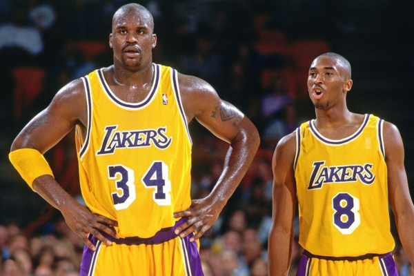 Regata Home Los Angeles Lakers Mitchell & Ness 1989 a 1997 nas cores amarela, branca e roxa. Design exclusivo que retrata a era dourada da equipe, com destaque para os momentos icônicos de Magic Johnson, Shaquille O'Neal e Kobe Bryant | Tevo Sports